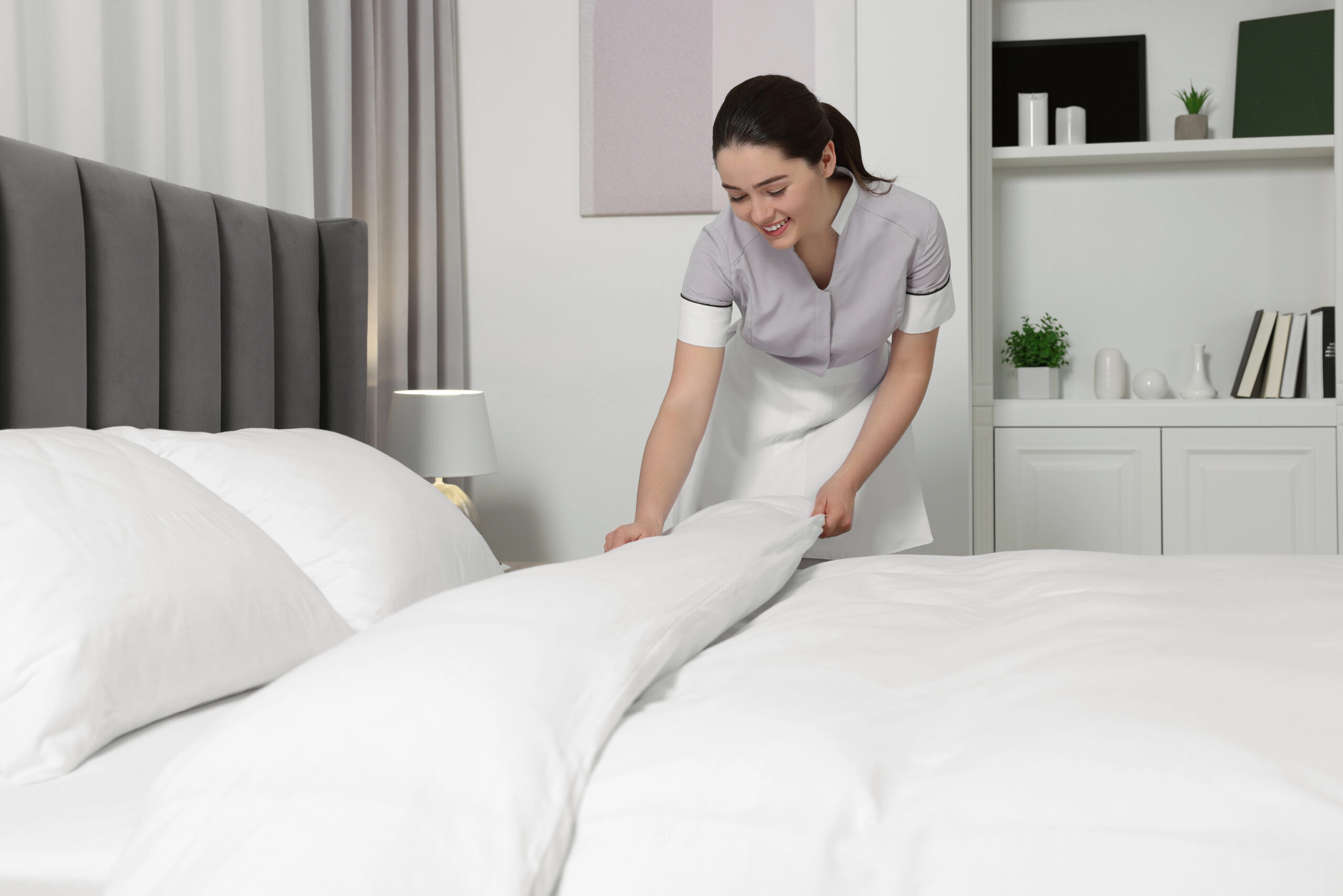 Hotelangestellte macht ein Bett ordentlich